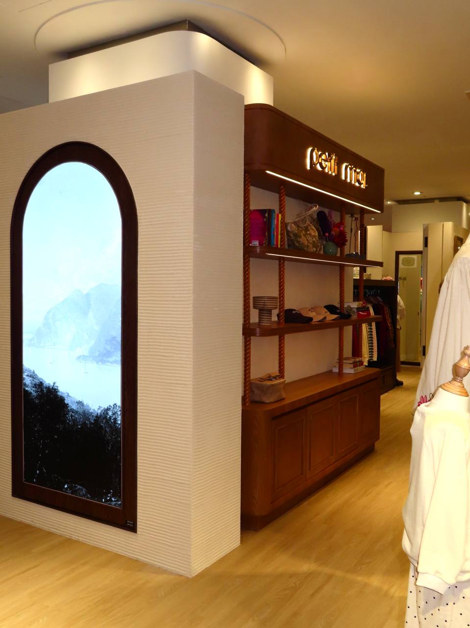 Petit Moi Isetan KLCC arched digital display in textured ivory walls beside timber shelving