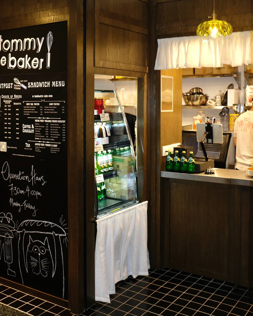 Tommy Le Baker counter with café curtains, handwritten signage and vintage-inspired pendant light